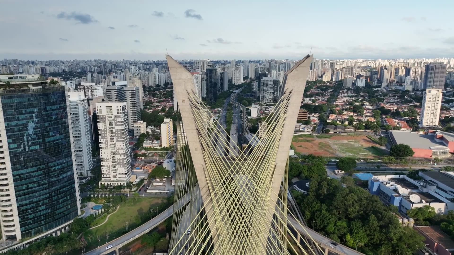 Aerial view of a cable-stayed bridge over a dense city skyline